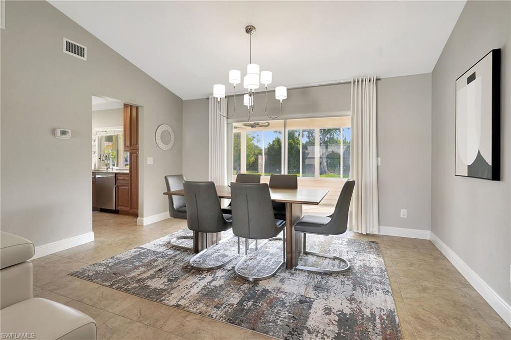 112 Versailles Circle Naples, FL 34112 - Photo 10 of 50 a view of a dining room with furniture a chandelier and wooden floor