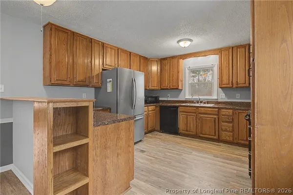 a kitchen with a refrigerator sink and cabinets