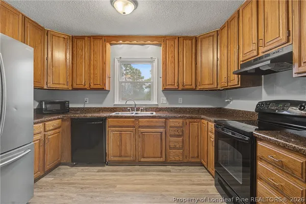 a kitchen with stainless steel appliances granite countertop a stove a sink and a microwave