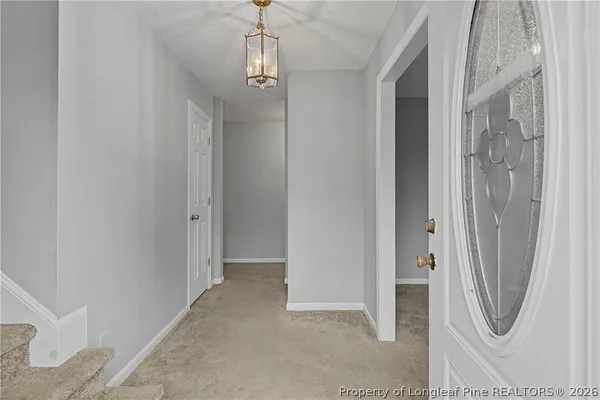 an empty room with a fireplace a ceiling fan and a window
