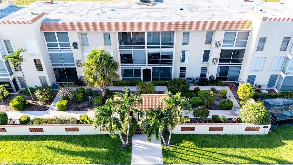 331 Southwest 8th Street, Unit 1CE Boca Raton, FL 33432 - Photo 1 of 4 front view of house with a yard and potted plants