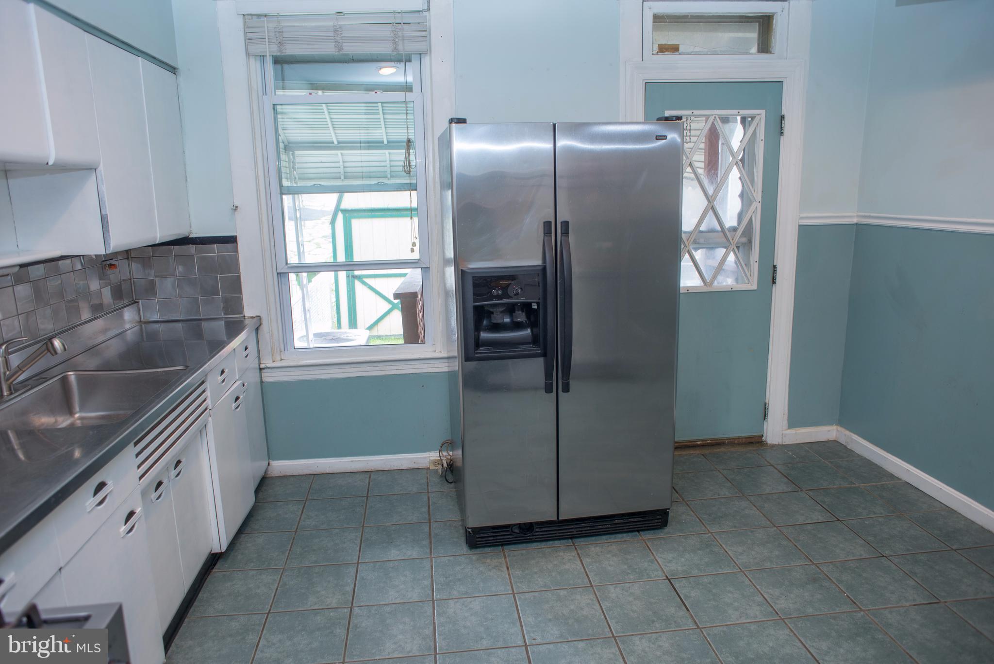 3652 Keswick Road Baltimore, MD 21211 - Photo 5 of 16 a kitchen with granite countertop a refrigerator and a sink