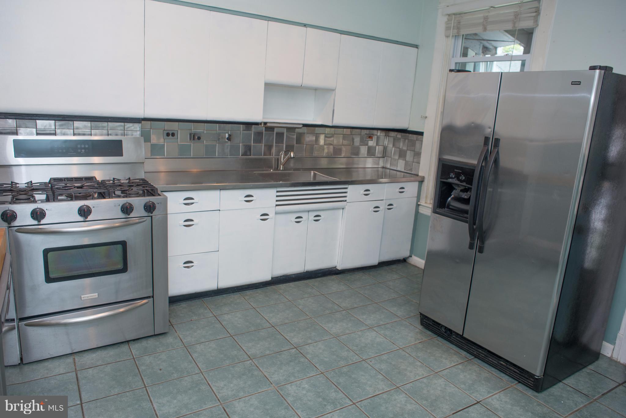 3652 Keswick Road Baltimore, MD 21211 - Photo 7 of 16 a kitchen with cabinets and stainless steel appliances