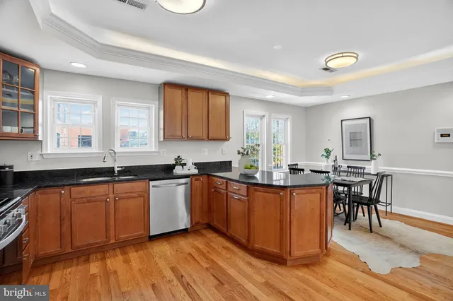 a kitchen with granite countertop a sink cabinets and wooden floor