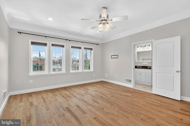 a view of an empty room with a window and wooden floor