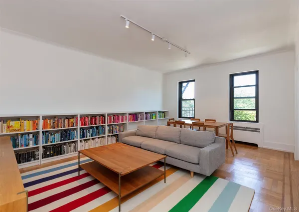 a living room with furniture and a book shelf