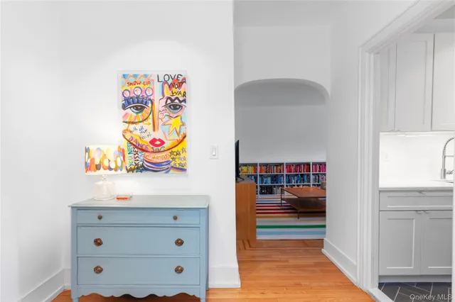 a hallway with painting and a table