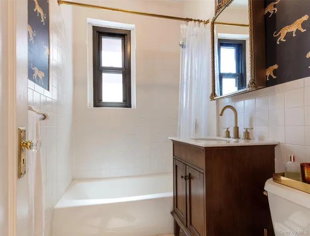 a bathroom with a sink and mirror with bathtub