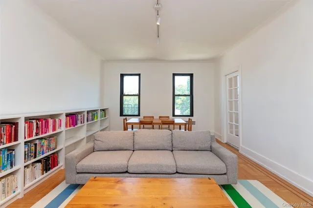 a living room with furniture and a book shelf