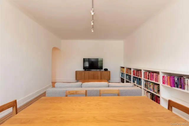 a living room with furniture and a book shelf