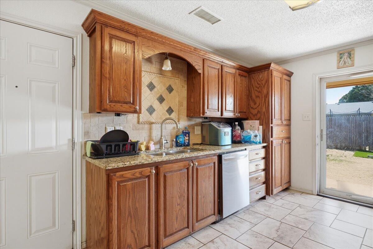 2101 76th Street Lubbock, TX 79423 - Photo 8 of 20 a kitchen with stainless steel appliances a stove a sink and a refrigerator
