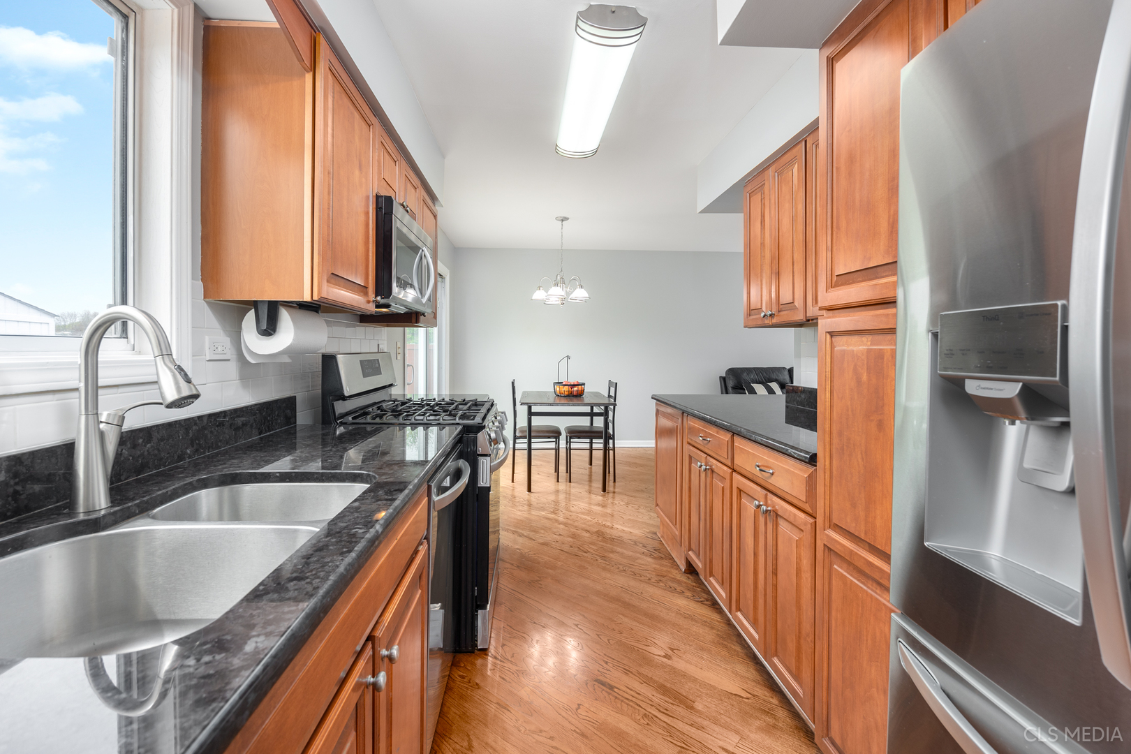 658 Cutter Lane Elk Grove Village, IL 60007 - Photo 7 of 33 a kitchen with stainless steel appliances granite countertop a sink a stove and a wooden floors