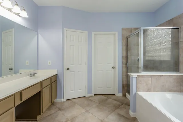 a bathroom with a tub sink and mirror