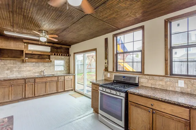 a large kitchen with granite countertop a large stove a sink dishwasher and cabinets