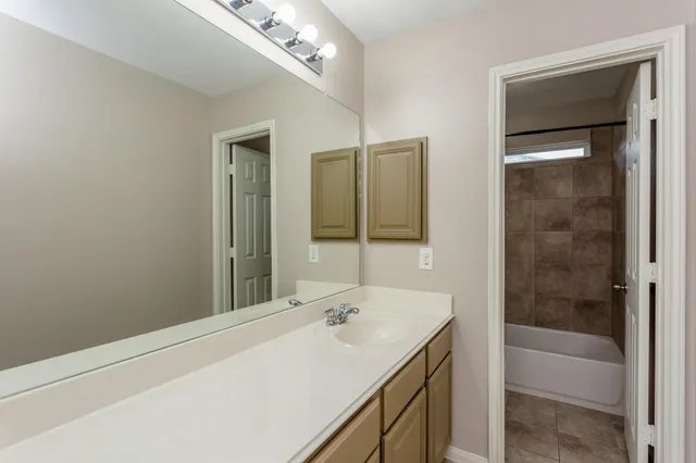 a bathroom with a tub sink and mirror
