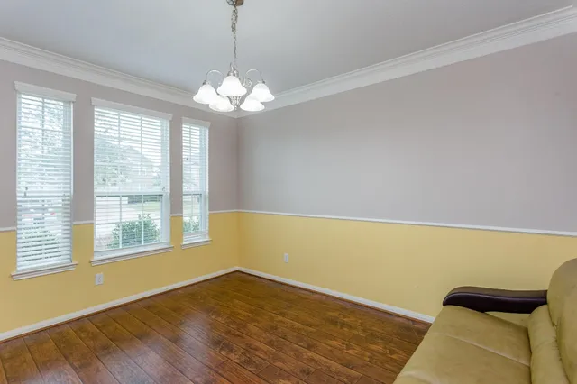 a view of a room with wooden floor and a ceiling fan
