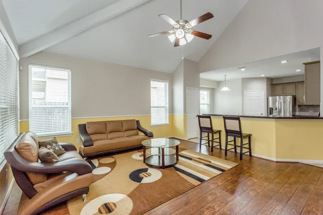 a living room with furniture and a wooden floor