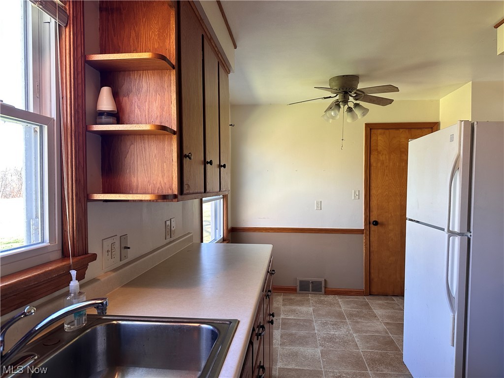 11617 Springfield Road North Lima, OH 44452 - Photo 8 of 28 Kitchen with white fridge, sink, ceiling fan, and dark tile floors