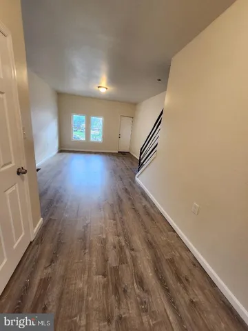 a view of a room with wooden floor and window