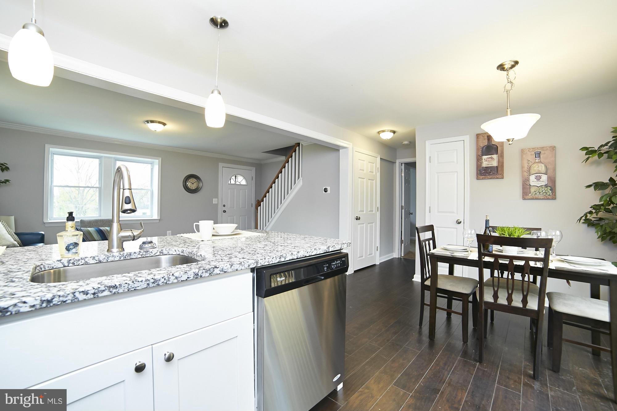 719 Cliffedge Road Baltimore, MD 21208 - Photo 11 of 30 a dining hall with stainless steel appliances granite countertop a stove a sink a dining table and chairs with wooden floor