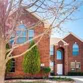 a front view of a residential houses with yard and trees