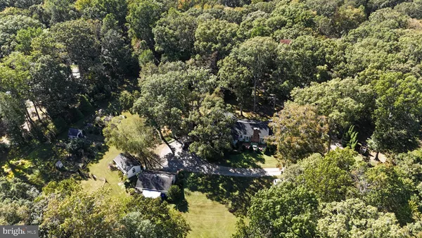 a front view of a house with garden and trees