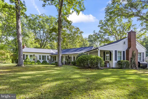 a view of backyard with a barn and a large tree