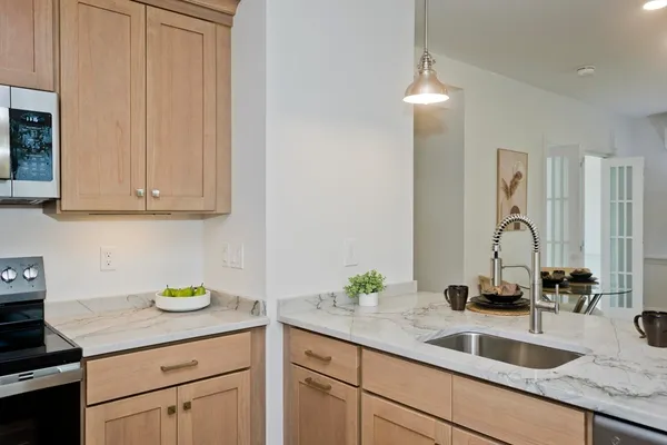a kitchen with granite countertop a sink stainless steel appliances and cabinets