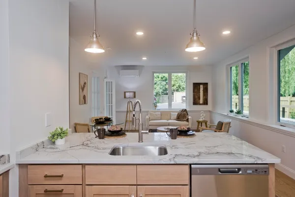 a kitchen with a granite countertop sink window and a white counter top