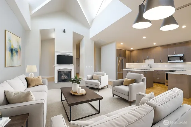 a living room with furniture kitchen view and a wooden floor