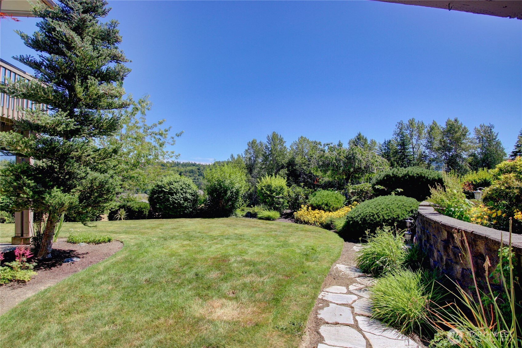 1408 Alpine View Place, Unit 2D Mount Vernon, WA 98274 - Photo 7 of 40 a view of a garden with plants and large trees