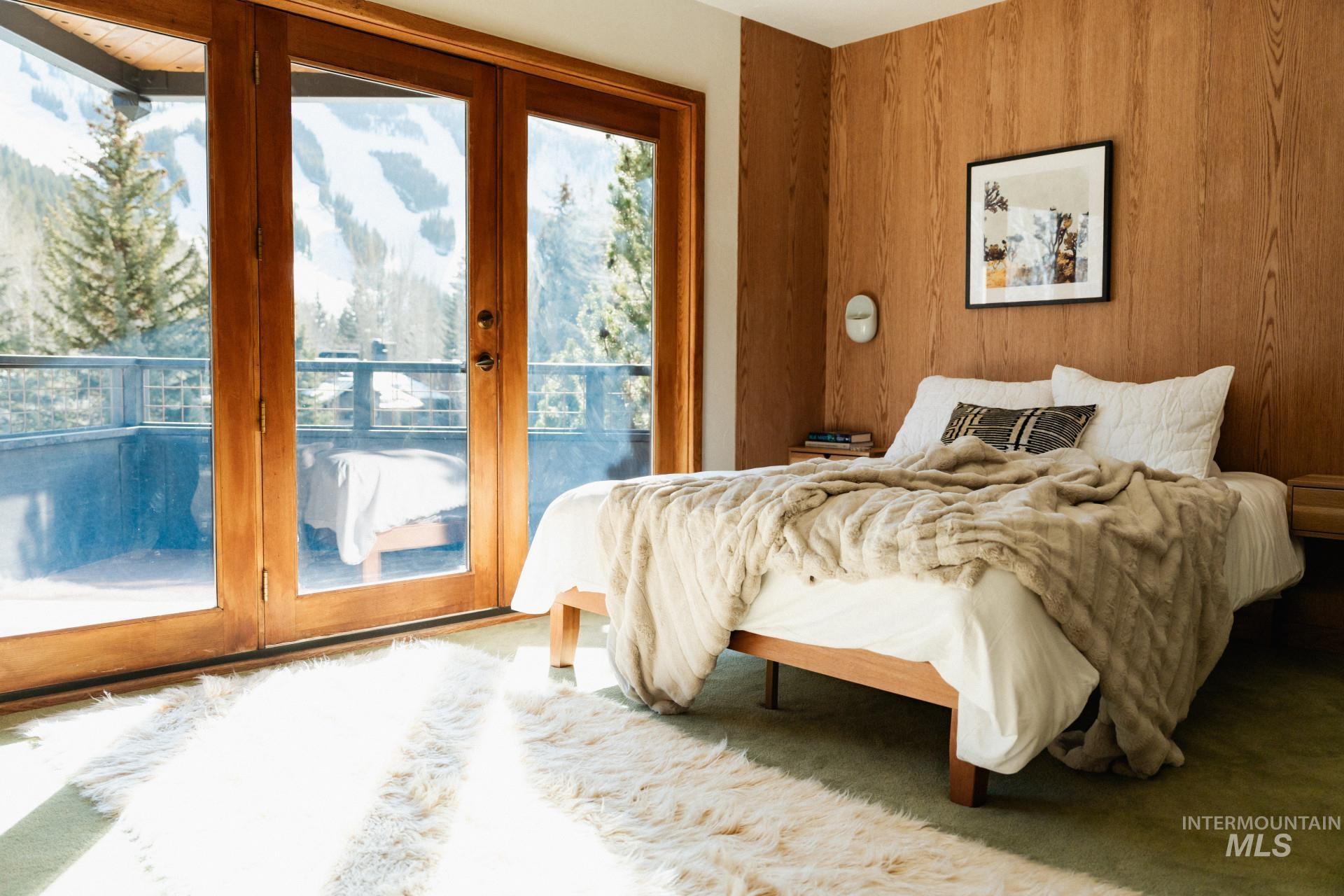 208 Georginia Road, Unit A Ketchum, ID 83340 - Photo 24 of 30 Wood-paneled accent wall, full-height glass patio doors, private balcony, and wall-mounted sconce