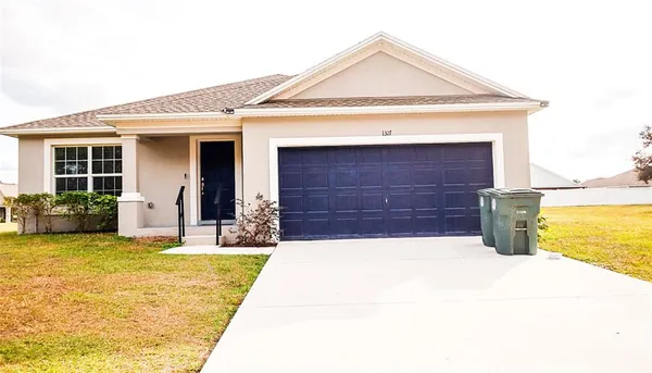 a view of a house with a yard and garage