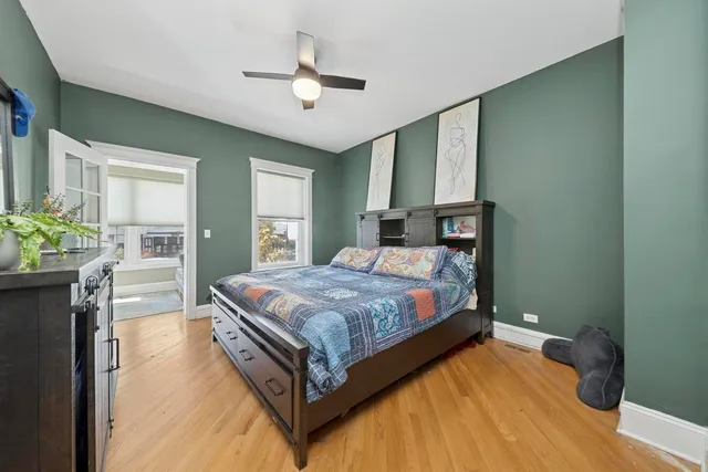 a bedroom with a bed chandelier and a window
