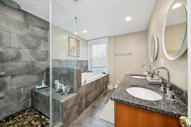 a bathroom with a granite countertop sink a mirror and a bathtub