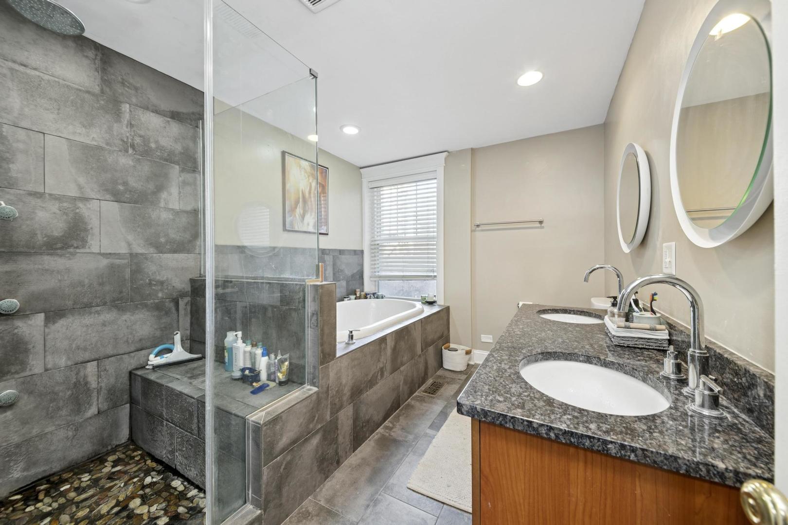 6743 North Sheridan Road, Unit 1N Chicago, IL 60626 - Photo 13 of 26 a bathroom with a granite countertop sink a mirror and a bathtub