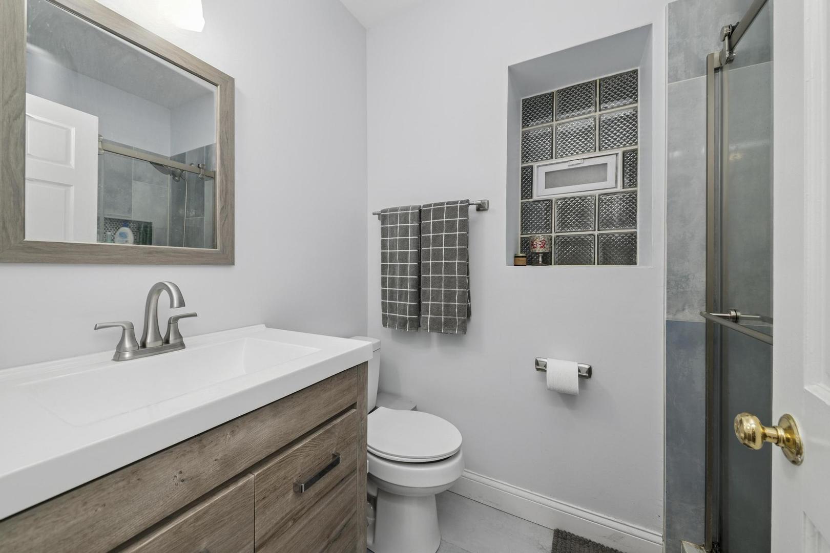 6743 North Sheridan Road, Unit 1N Chicago, IL 60626 - Photo 21 of 26 a bathroom with a sink toilet and a mirror
