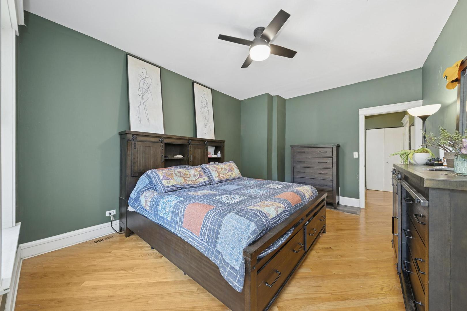 6743 North Sheridan Road, Unit 1N Chicago, IL 60626 - Photo 10 of 26 a bedroom with a large bed a chandelier and dresser