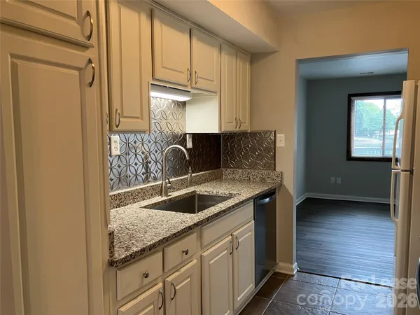 a kitchen with granite countertop a sink and a stove