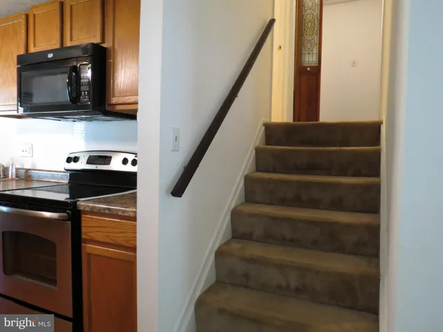 a view of an empty room with stairs and a window
