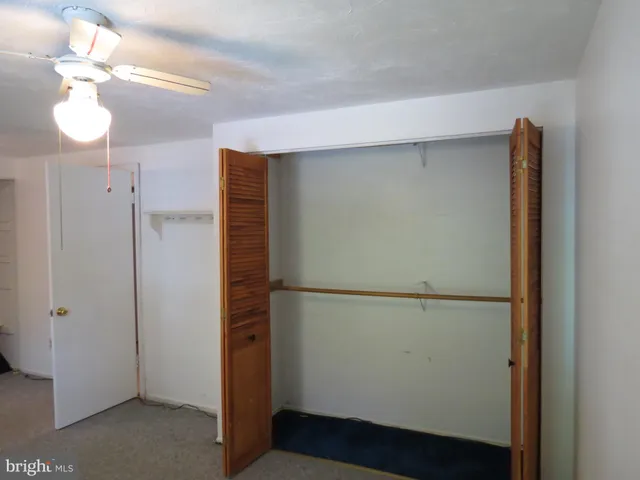 a view of an empty room with a cabinet and mirrors