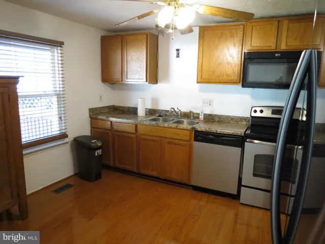 a living room with furniture and a refrigerator