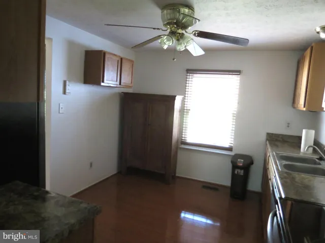 a kitchen with a sink cabinets and wooden floor