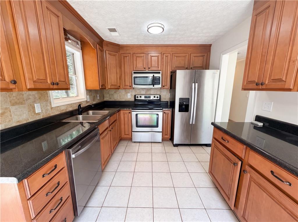 722 Ridgetop Road Bethlehem, GA 30620 - Photo 9 of 23 a kitchen with stainless steel appliances granite countertop a refrigerator a sink a stove top oven and a dishwasher