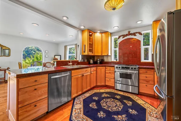 a kitchen with stainless steel appliances granite countertop a stove a sink and a refrigerator