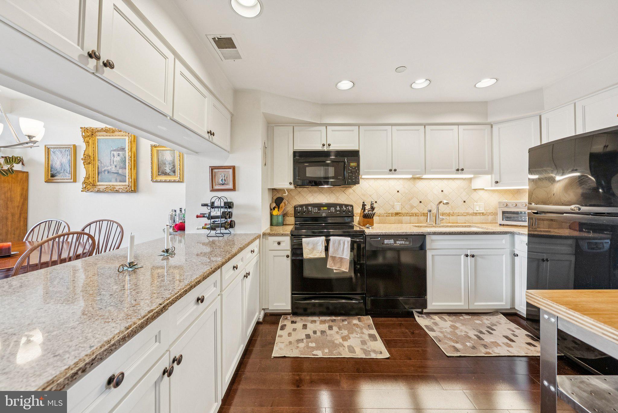 1301 North Courthouse Road, Unit 1810 Arlington, VA 22201 - Photo 3 of 29 a kitchen with kitchen island granite countertop a stove sink and cabinets