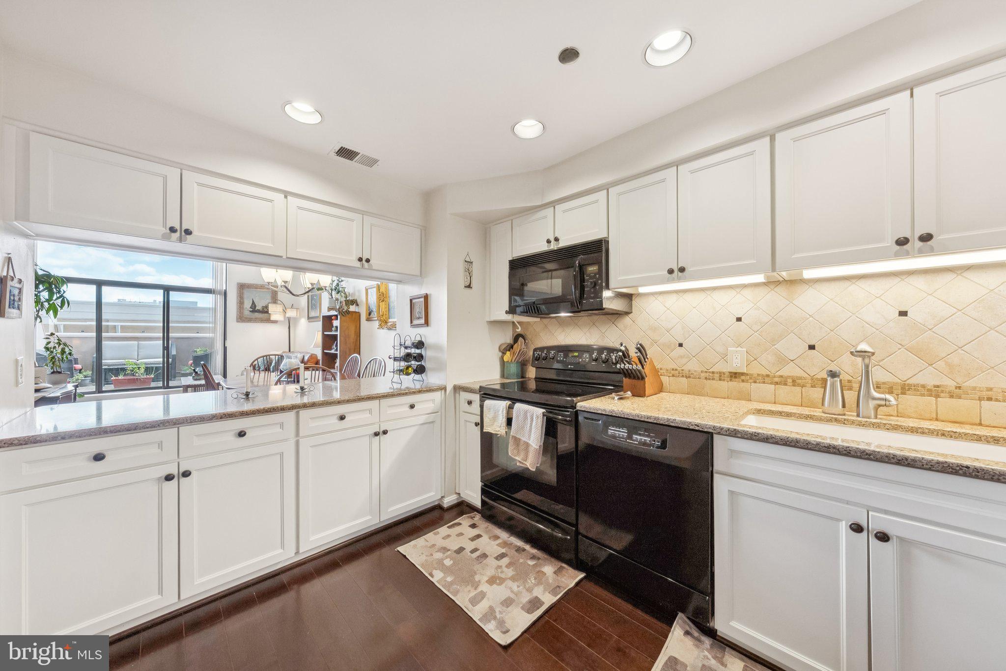 1301 North Courthouse Road, Unit 1810 Arlington, VA 22201 - Photo 4 of 29 a kitchen with granite countertop a sink stainless steel appliances and cabinets