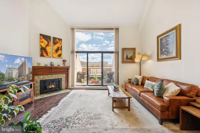 a living room with furniture a flat screen tv and a fireplace