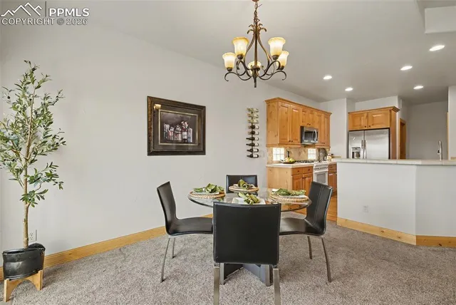 a dining room with furniture potted plants and wooden floor