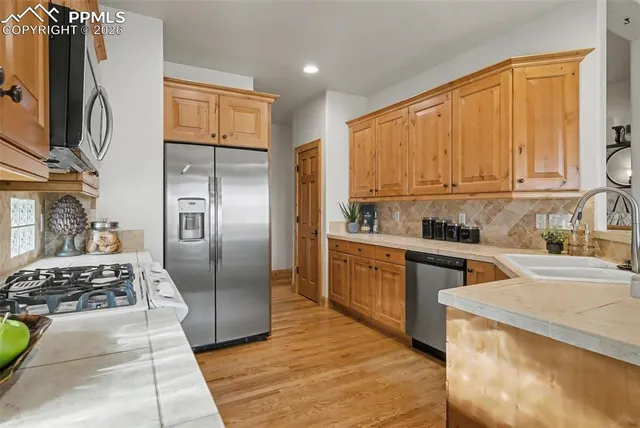 a kitchen with stainless steel appliances granite countertop a stove a refrigerator and a sink